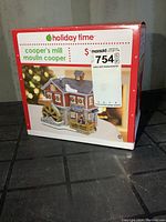 Photo of the original box featuring Holiday Time Cooper's Mill Christmas Village with label and price sticker