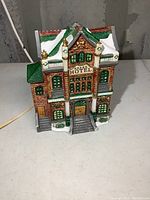 Front view of the Grand Hotel building with visible sign and roof details. Plug cord visible at the side.