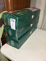 Three green boxes of Holiday Collection outdoor illuminated garland stacked on top of each other.