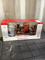 Front view of Santa's Express Musical Train in original box showing the train and figures with clear display window.