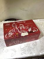 Red box of Cristal d'Arques 5 piece Nativity Scene set, featuring product name and picture of crystal figurines.