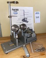 Front view of the pearl drill with adjustment knobs and metal components, bag of parts visible.