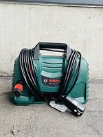 Front view of Bosch EasyAquatak 1700 pressure washer with hose wrapped around the unit and Bosch logo visible.