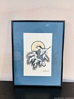 Front view of framed bird painting with blue mat and black frame