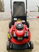 Front view of red Troy-Bilt lawn mower showing Honda GCV160 engine cover, pull start, and tires.