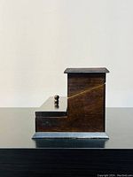 Side view of vintage Bombay Company wooden jewelry box showing stepped design and dark brown finish.