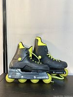 Side view of vintage Rollerblade Lightning inline skates, showing neon yellow wheels, black frame, and neon yellow lining and lace.
