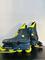 Side view of vintage 1988 Rollerblade Lightning inline skates showing black and neon yellow boots with yellow wheels