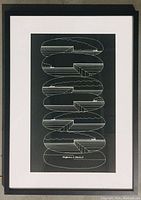 Full view of framed print showing black frame, white mat, and geometric black-and-white silkscreen design