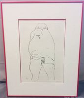 Full view of framed etching artwork showing the nude figure with the pink frame and white mat.