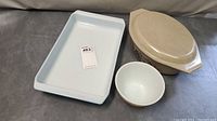 Overall view of all three kitchenware items: Pyrex Baker Blue rectangular dish, Homestead small bowl, and Homestead covered casserole dish with lid.