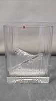 Front view of clear square heavy art glass vase with textured vertical ridges and diagonal wave.