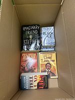 Photo of a box containing five books including Imaginary Friend by Stephen Chbosky and George Eastman biography.
