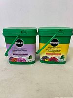 Two buckets of Miracle-Gro plant food: Bloom Booster and All Purpose.