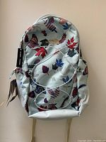 Full front view of The North Face backpack with fall leaf and butterfly print showing design and general condition.