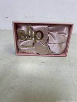 Pink satin turban in original transparent SLIP branded box, showing fabric texture and color.