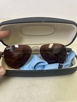 Ray-Ban RB3689 aviator sunglasses displayed in open hard navy case with blue cleaning cloth inside.