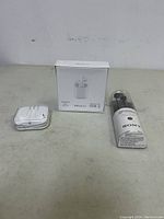 Photo showing wireless earbuds charging case, wired Apple-like earbuds in plastic case, and Sony headphones container.