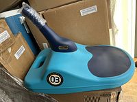 Photo showing the blue and black Zip Fly freestyle mini luge, highlighting its compact design and handlebar wrapped with tape.