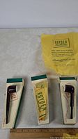 Three Royden Meer-Tone tobacco pipes in dark brown with cream mouthpieces, presented in original green and white boxes along with original yellow branded paper wrapping.