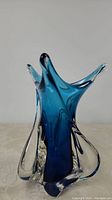 Front angle of the blue and clear twisted art glass vase showing contours and glossy blue swirl.