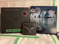 Photo of the two hardcover Canada Post stamp books with a small box in front. Books are sealed and show limited edition stickers for pricing.