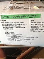 Box showing product information including brand 'Polytree', dimensions 2x 4ft patio Christmas trees, shipped from Hong Kong, sold at Michaels.