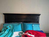 Headboard with paneled design and bedding visible
