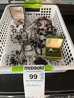 Full view of fashion jewelry pieces in white basket with MaxSold tag showing black beads and green velvet ring box.