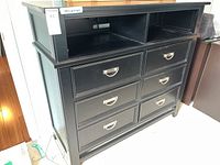 Front view of the black lacquer dresser showing six drawers and two open shelf compartments.
