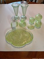 Full set of nine uranium glass pieces displayed on white surface under ambient light