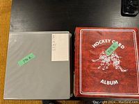 Photo of two binders holding hockey cards, one gray and one red labeled 'Hockey Card Album'