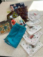 Lot of 5 vintage handkerchiefs and 6 scarves laid out on table showing variety in size, pattern and color