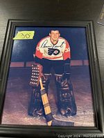Framed 8x10 color photo of Bernie Parent in Flyers uniform on ice, signed on the top left side of photo.