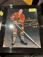 Framed 8x10 photo of Bobby Hull in Blackhawks uniform with gold signature visible on right side of photo.