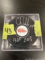 Signed Chris Chelios Detroit Red Wings hockey puck in clear display case with signature and inscription 'HOF 2013' visible
