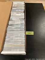 Full cardboard box filled with a large stack of hockey rookie cards.