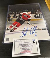 Photo of signed 8x10 photo of John Leclair in Flyers uniform with Certificate of Authenticity.