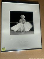 Framed black and white photo of Marilyn Monroe taken by Milton H. Greene, in a silver frame with white matting and photographer credit on mat.