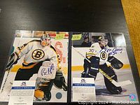 Two 8x10 color photos of Boston Bruins goalies Bill Ranford and Jon Casey, each signed with blue ink and shown in full goalie gear on the ice. Both photos include certificates of authenticity and protective sleeves.
