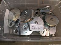 Bin with multiple metal Campbell fixed utility pulleys of varying sizes.