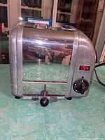 Front view of Dualit toaster model A2BR/87 showing stainless steel sides and black controls with the brand name embossed on the side.