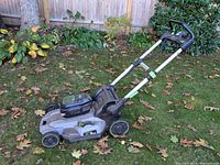 Side angle of EGO Power+ mower on grass showing deck, wheels, and battery compartment