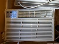 Front view showing GE logo, control panel with buttons and digital display, and air vents.