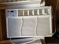 Front view of one GE window air conditioner showing control panel, vents, and power cord.