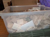 Large plastic tub filled with many individually wrapped and packed small lab glass items.