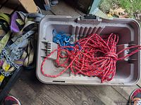 Rope and straps arranged inside plastic container, visible braided rope and portion of straps