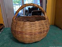 Front view of handmade wicker basket showing overall shape and handle