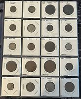 Full view of 20 assorted world coins individually sleeved with handwritten labels indicating year, country, and denomination.