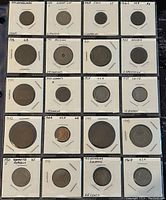 Front view of all 20 coins individually mounted in labeled white holders.